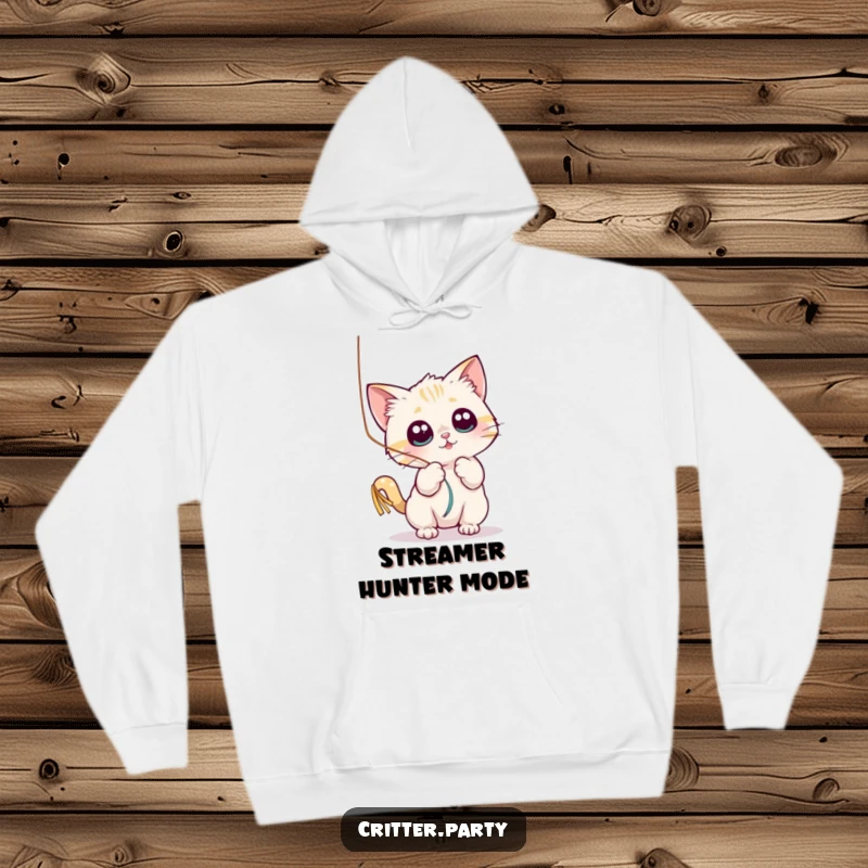 Funny hoodie with a small cat character playfully batting at a shiny, dangling streamer with wide, captivated eyes.