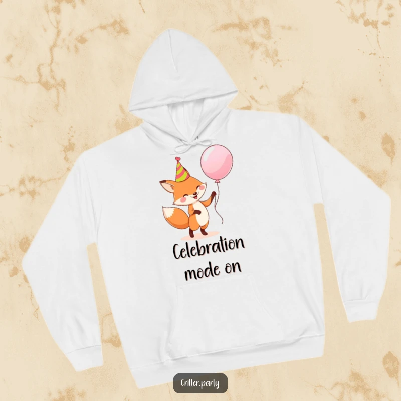 Funny hoodie: A happy fox in a party hat dancing joyfully with a large balloon, radiating festive humor.