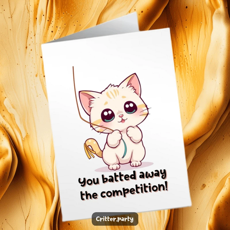Funny Free Printable Congratulations Card: A small cat playfully batting a shiny streamer with wide eyes, a fun downloadable.